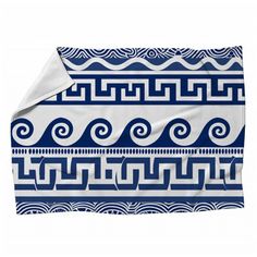 a blue and white blanket with an abstract design on the bottom, along with waves