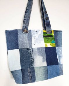 a patchwork denim tote bag hanging on a wall