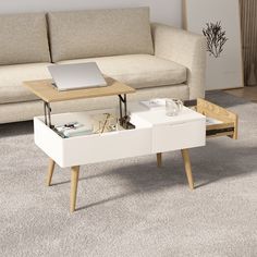 a living room with a couch, coffee table and laptop on top of the table