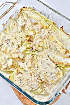 a casserole dish with artichokes and sauce in it on a table