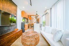 a living room filled with furniture and a flat screen tv on top of a wooden stand