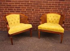 two chairs sitting next to each other in front of a brick wall