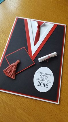 a graduation card on a table with a tie and diploma pinned to the back of it