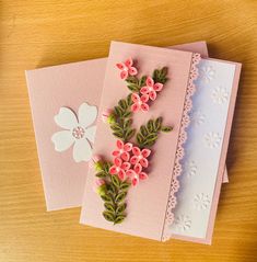 two cards with flowers on them sitting next to each other