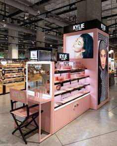 the inside of a cosmetics store with pink counter tops and shelves filled with makeup products