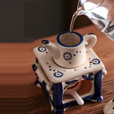 a pitcher pouring water into a small teapot