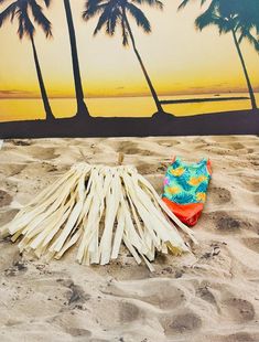 a pile of toothpicks sitting on top of a sandy beach next to palm trees