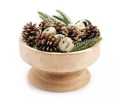 a wooden bowl filled with pine cones and ornaments