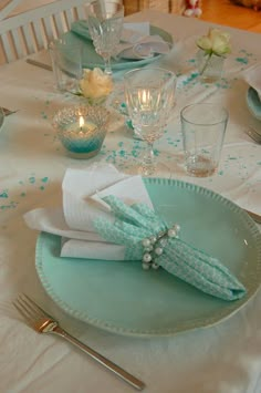 the table is set with blue and white dishes, silverware, and napkins