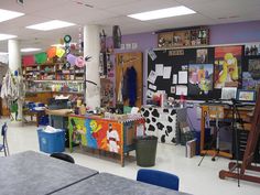 an empty classroom with desks, chairs and pictures on the wall