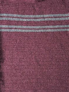 a close up view of the side of a red sweater with white and blue stripes