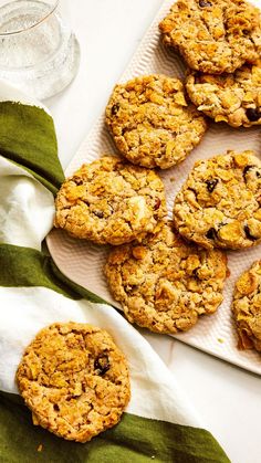 oatmeal raisin cookies on a plate next to a glass of water