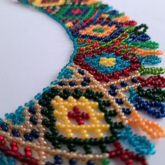 the beaded necklace is being displayed on the table