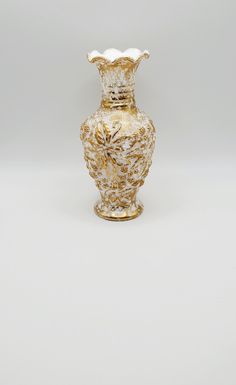 a gold vase sitting on top of a white table