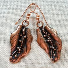 "Carefully antiqued to bring out every delicate detail, these lovely earrings offer you a sophisticated and natural look you will enjoy for day and evening wear. Metal leaves are anodized for a copper look. Hooks are copper. Drop is a generous 2 1/2\" (6 1/2cm). Boxed. (#1030). International Customers-- We are delighted to ship internationally to many locations. Please be familiar with your own country's customs duties, fees, VAT, delivery charges or taxes on the items you order, as these are yo Antique Finish Copper Drop Earrings, Antique Finish Copper Dangle Earrings, Elegant Bronze Copper Earrings, Antique Finish Copper Earrings As Gift, Bronze Copper Leaf-shaped Jewelry, Elegant Copper Leaf Jewelry, Elegant Patina Earrings For Gifts, Nickel-free Bronze Copper Earrings, Franklin Tn