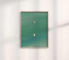 two surfers are swimming in the ocean with their surfboards under them, framed in wood