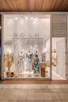 a store front window with clothes and baskets in the display case, which reads boa h