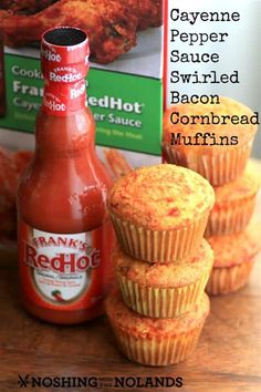 some food is sitting on a table next to a bottle of hot sauce and muffins