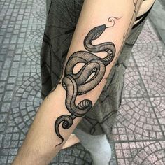 a man's arm with a tattoo on it that has a snake in the middle