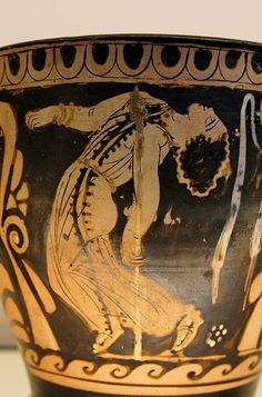 an ancient greek vase with the image of a man holding a spear and kneeling down