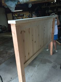 a woman standing next to a wooden counter in a garage