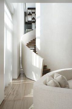 a white couch sitting next to a spiral staircase