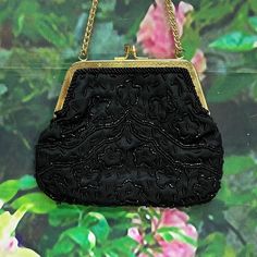 "Vintage lightweight evening purse from the 1970's made in Hong Kong by Richere. Black satin handbag has a floral design in small black glass beads. Gold tone engraved frame and kiss closure with double wrist chain. Interior is black satin with one pocket. Purse measures 7\" by 5\". Clean condition inside and out. Please see photos for more details. All items are vintage that are preowned. All of the items may show some form of wear due to their age. Please kindly remember that these items are a Antique Style Evening Clutch Bag, Black Rectangular Evening Coin Purse, Elegant Black Coin Purse For Evening, Elegant Evening Bags With Black Beads, Elegant Black Evening Coin Purse, Black Evening Coin Purse Clutch, Vintage Black Evening Bag For Party, Black Clutch Coin Purse For Evening, Antique Beaded Evening Bag