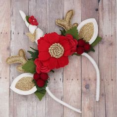 the headband is decorated with red flowers and gold sequins, along with white antlers