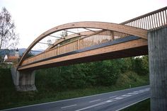 a wooden bridge over a road in the countryside