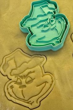 two cookie cutters with the grin face and hat on them next to each other