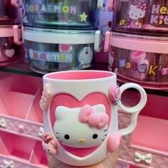 a hello kitty coffee mug is held up