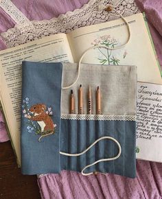 an open book with crayons on it next to a bag and some other items