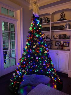 a brightly lit christmas tree in a living room