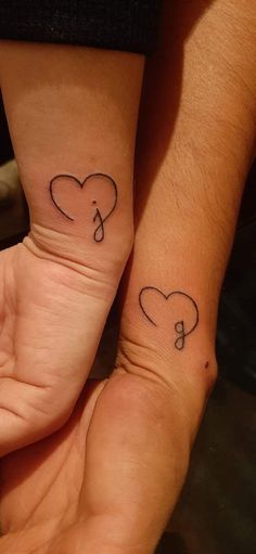 two people with matching tattoos on their hands