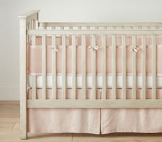 a crib with pink and white bedding on the bottom row, in front of a wall