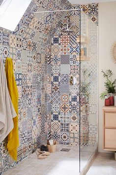 a bathroom with blue and white tiles on the walls, shower stall and sink area