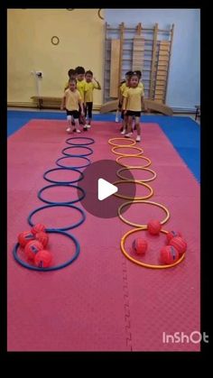 some kids are playing with balls in a gym