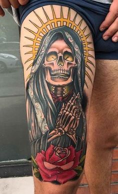 a man's thigh with a tattoo on it and a skeleton holding a rose