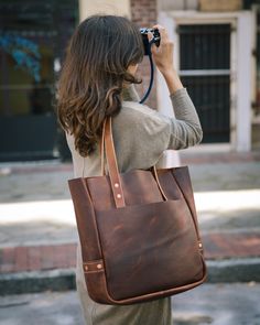 a woman holding a camera up to her face