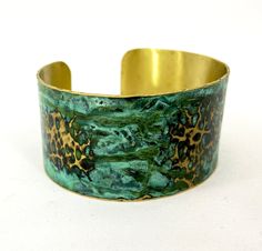 These unique, hand-formed copper and brass cuff bracelets with vibrant patinas create stunning accents to your personal style. Dress up or down- either way you'll be wearing an adornment that will turn heads, start conversations, and delight the eye of the beholder. This is a hammered Brass cuff with gorgeous marbled green/blue patina. Please note that patina colors will look different depending on the screen/device you view them on. This is a medium cuff- see measurements below. Cuffs have a 1” Green Patina Bangle Bracelet, Green Bangle Bracelets With Patina, Bronze Bangle Bracelet With Patina, Green Patina Cuff Bracelet Gift, Green Patina Cuff Bracelet As Gift, Bronze Bangle Bracelet In Wearable Art Style, Adjustable Patina Bangle As Gift, Patina Brass Bangle Bracelet, Brass Cuff Bracelet With Patina As A Gift