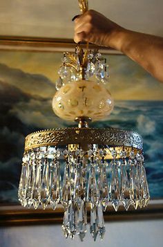 a chandelier hanging from the ceiling in a room with paintings on the wall