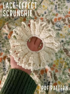 a hand holding a crocheted flower with the text lace effect scrunchie