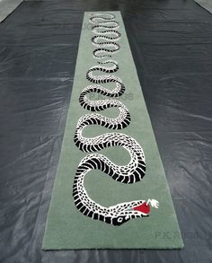 a long line of black and white snakes on a green surface