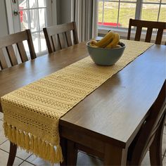 a bowl of bananas sitting on top of a wooden table