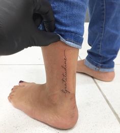 someone is getting their foot tattooed with the words love and strength written on one side