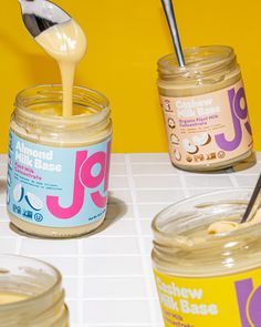 jars of peanut butter and vanilla ice cream are being poured into each jar with a spoon