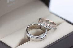 two wedding rings sitting in a box on display