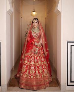 a woman in a red and gold bridal gown