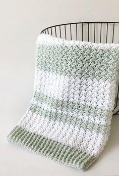 a crochet baby blanket sitting on top of a chair