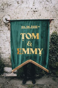 a banner that says tom and jimmy hanging on the side of a building with ivy growing around it